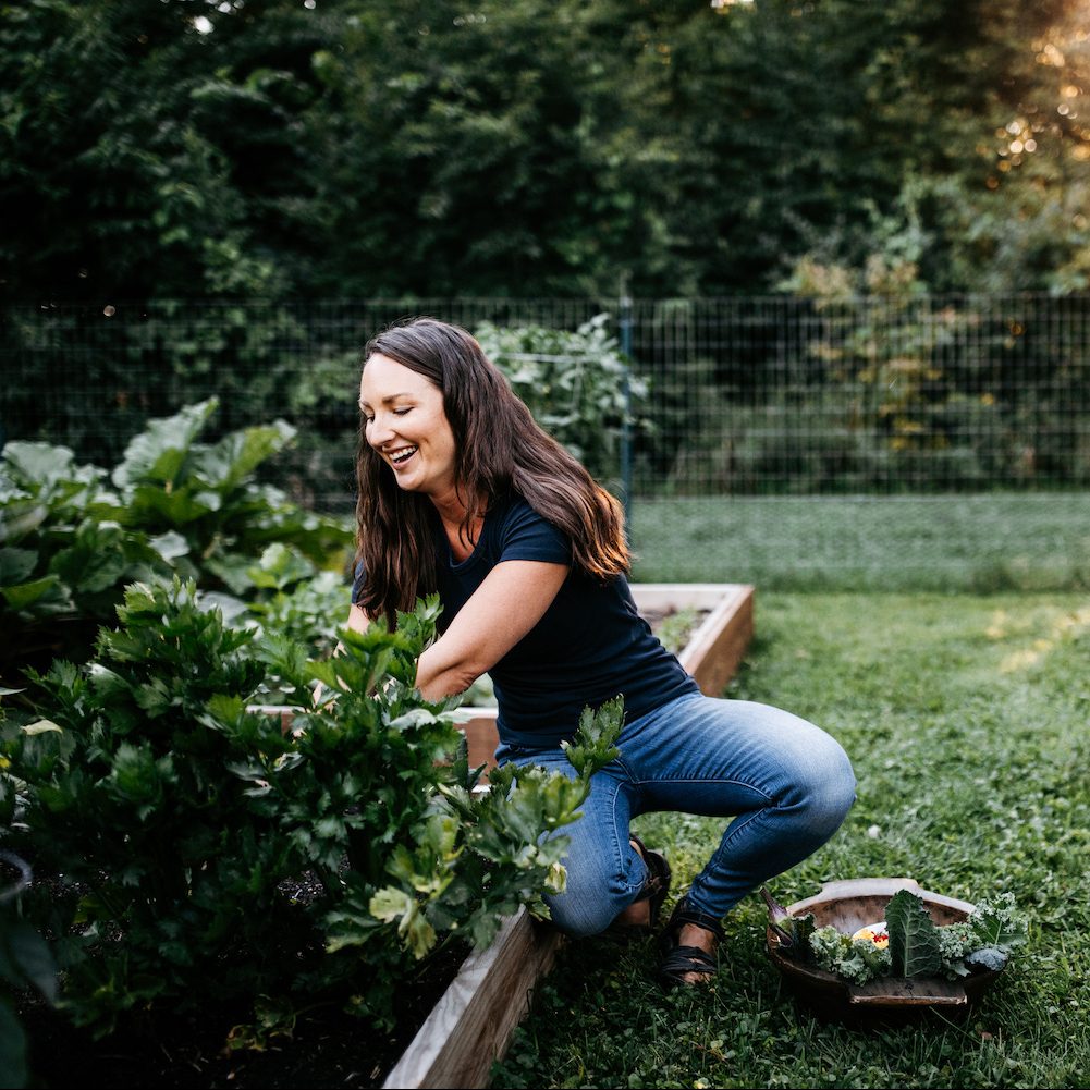 Katie working in her garden smiling and not looking at the camera